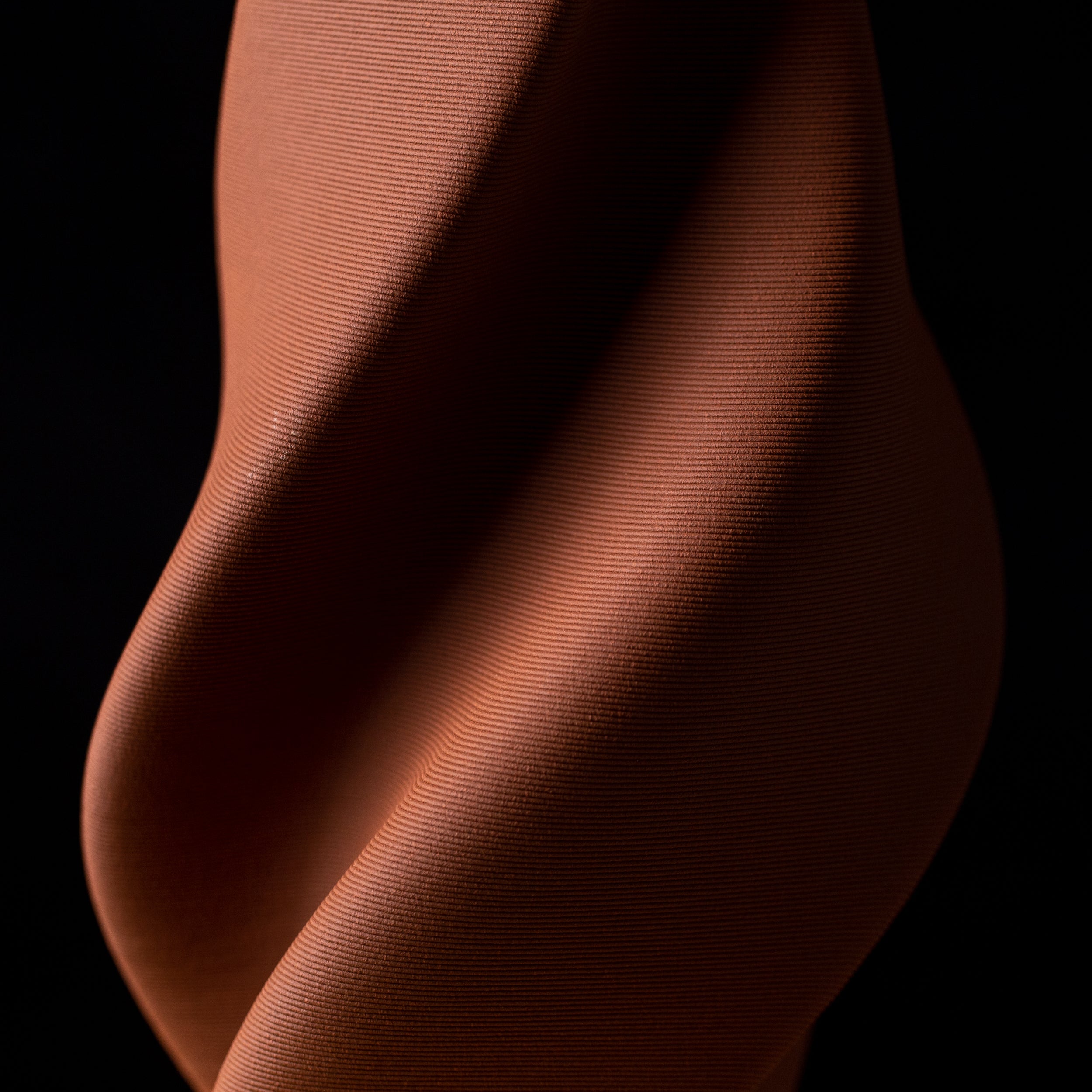 3D-printed ceramic sculpture from the Tornado collection in red clay, featuring spiraling form and dynamic movement