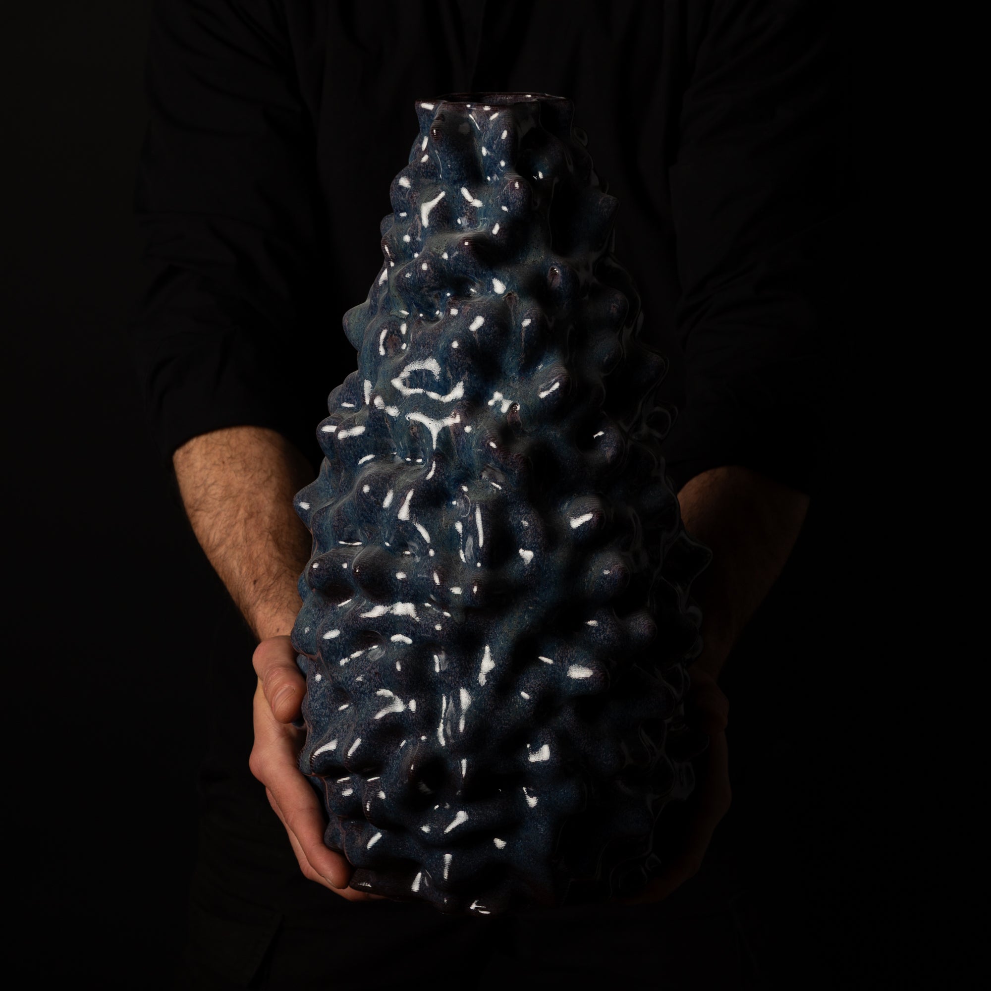 A-0100 Alien Organic Sculpture – Black Clay Blue Glaze – artist holding – BinaryCeramics Athens