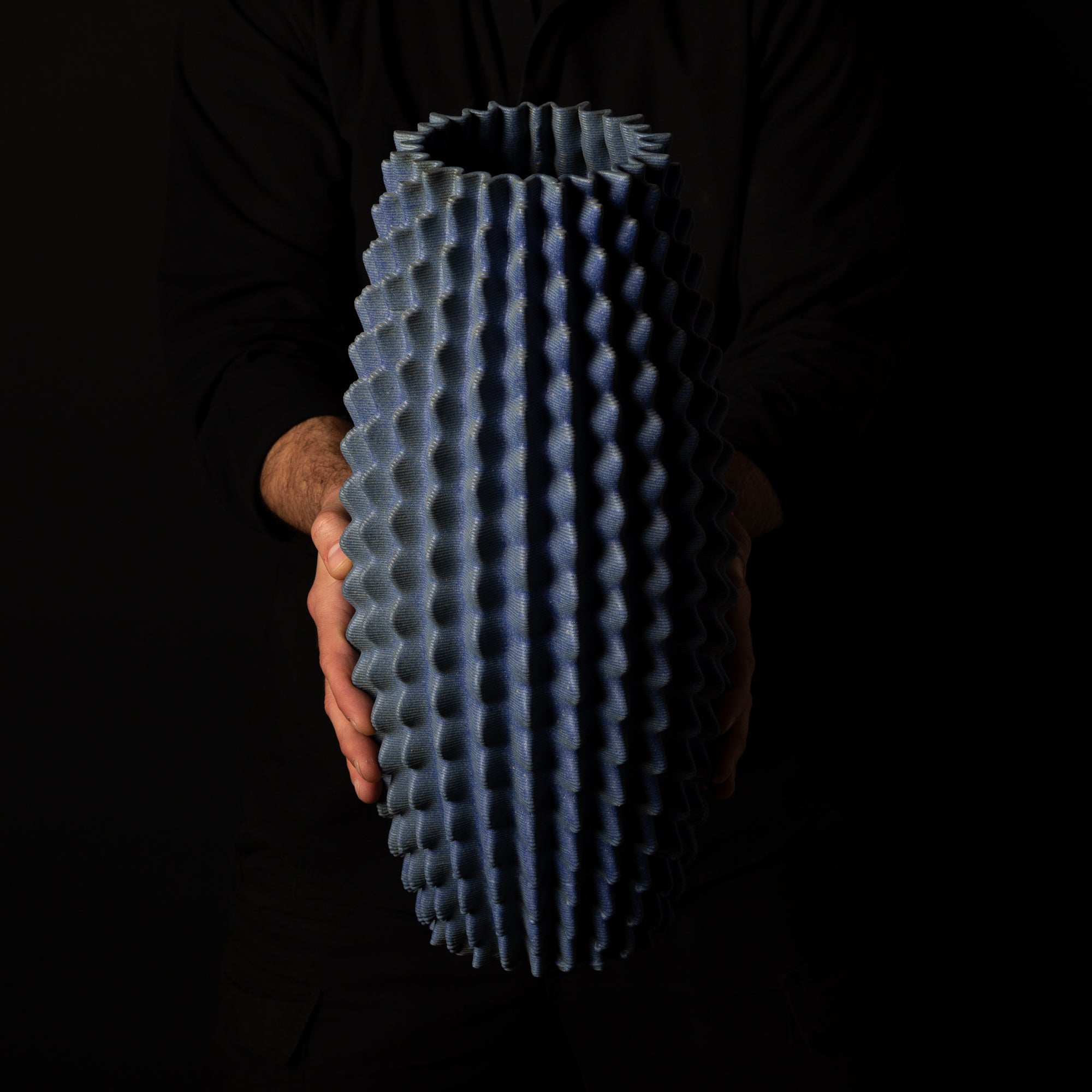 C-0001 Cactus Organic Form – Black Clay Blue Glaze – artist holding side view – BinaryCeramics Athens