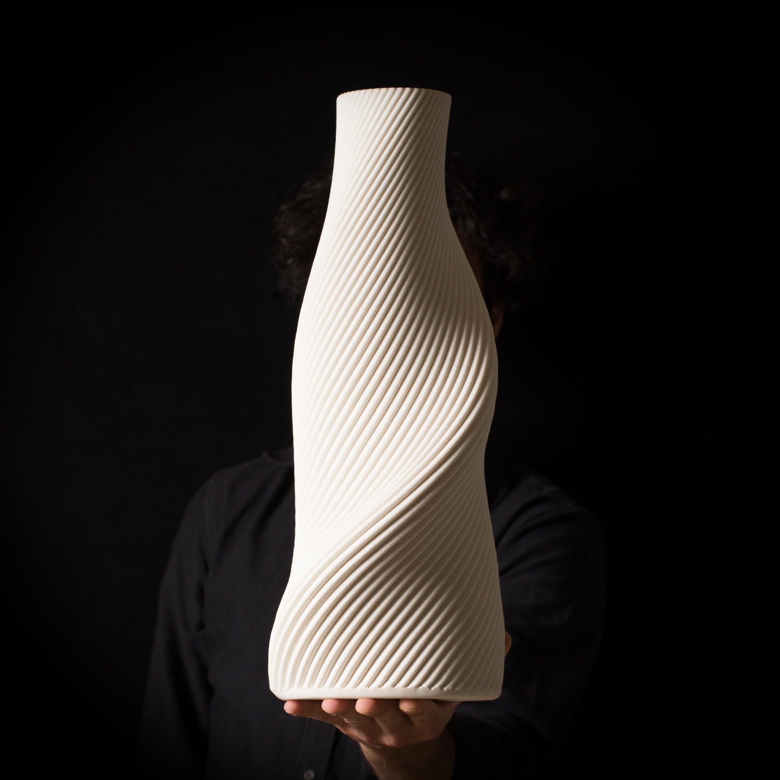 3D-printed ceramic in porcelain form from the Tornado collection, featuring dynamic spiral geometry and textured surface.,